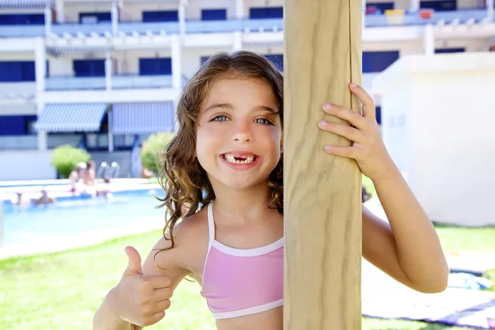 Framed Print : Indented kid girl ok gesture in pool garden holding sunroof pole