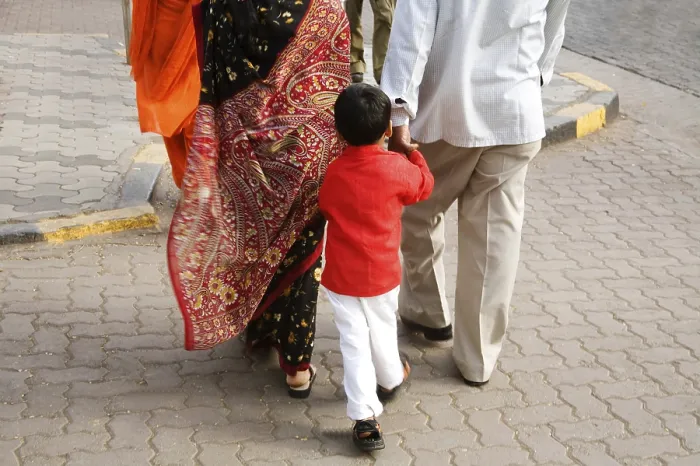 Framed Print : Indian Boy wearing red color shirt following the parents