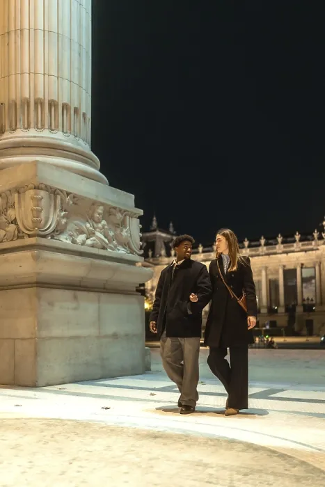 Framed Print : Interracial couple strolling arm in arm past an illuminated historic monument at night Framed Print : Interracial couple strolling arm in arm past an illuminated historic monument at night