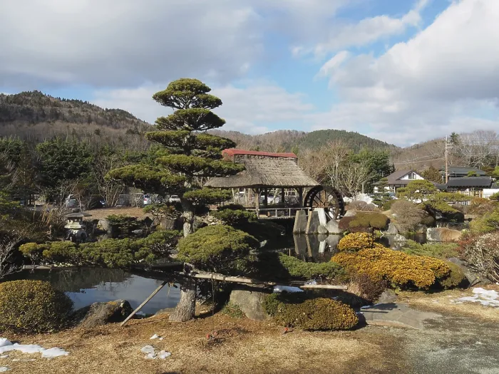 Framed Print : Japanese garden with traditional house and well-kept trees against mountain backdrop