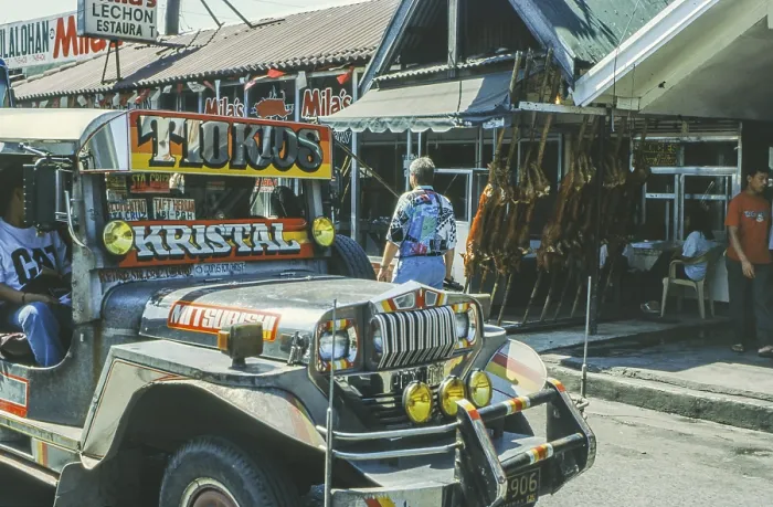 Framed Print : Jeepney minibus in front of a restaurant with skewered suckling pig