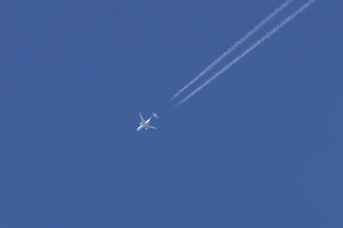 Framed Print : Jet passenger aircraft with a vapour trail or contrail flying in a blue sky