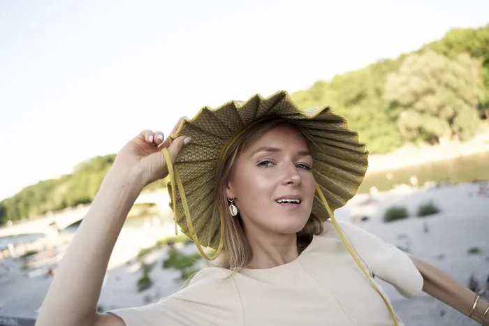 Framed Print : A joyful woman in a straw hat offers a playful pose outdoors in a summer setting on Praterinsel of river Isar in Munich