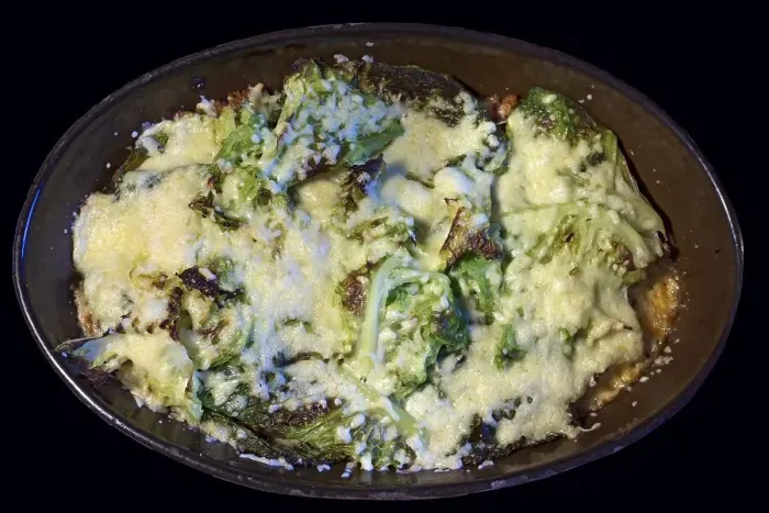 Framed Print : Kale gratinated with cheese and minced meat in an earthenware casserole on a black background