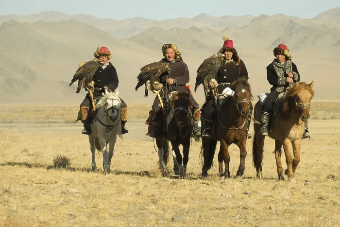 Framed Print : Four Kazakh eagle hunters on their horses on the way to the Eagle Festival in Sagsai