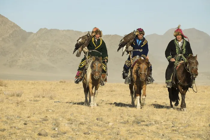 Framed Print : Three Kazakh eagle hunters on their horses on the way to the Eagle Festival in Sagsai