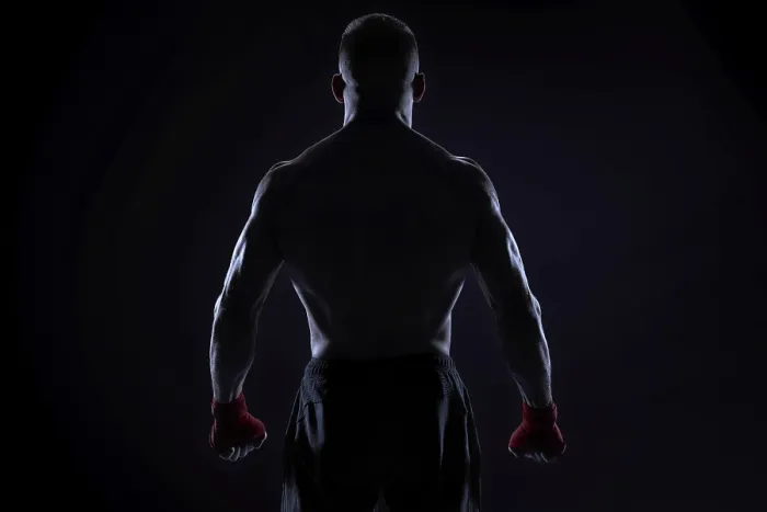 Framed Print : Kickboxer in red bandages posing on a blue background
