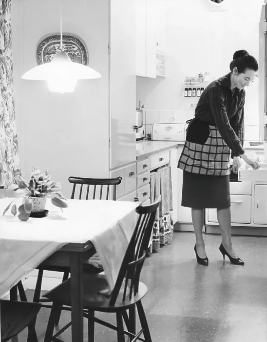 Framed Print : In the kitchen 1960s. Interior of a kitchen and a women taking something from a kitchen drawer Framed Print : In the kitchen 1960s. Interior of a kitchen and a women taking something from a kitchen drawer