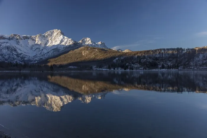 Framed Print : Lake Almsee in winter. Snow on the mountains and a clear blue sky