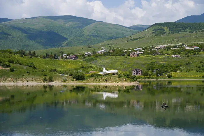 Framed Print : Lakeside village with mountains in the background Framed Print : Lakeside village with mountains in the background