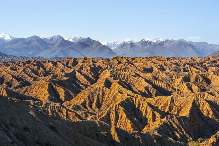 Framed Print : Landscape of eroded hills, white peaks of the Tien Shan Mountains in the background