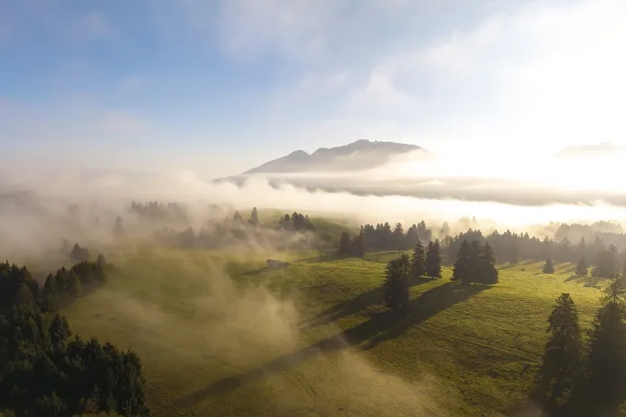 Framed Print : Landscape at sunrise with fog over a green meadow and mountains in the background Framed Print : Landscape at sunrise with fog over a green meadow and mountains in the background