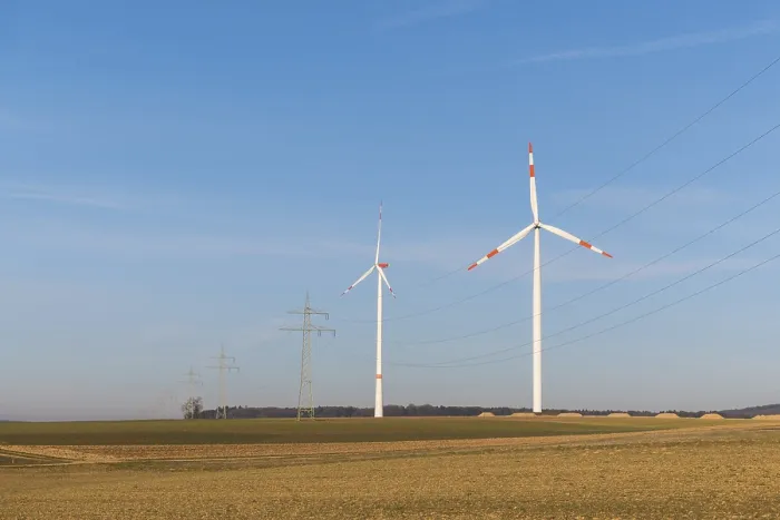 Framed Print : Landscape with wind turbines and power lines in front of a blue sky