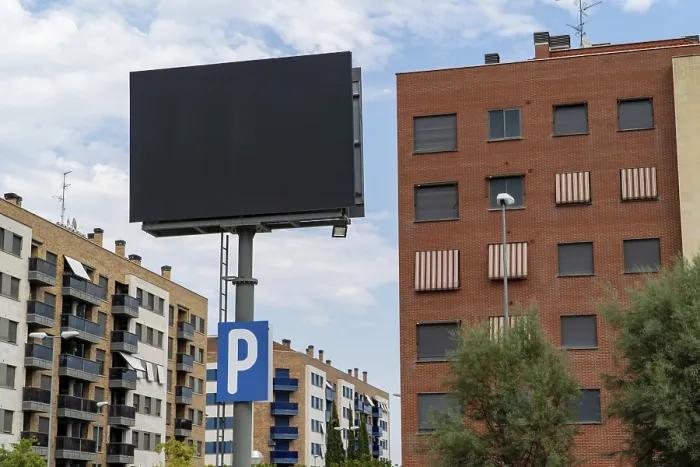 Framed Print : A large, blank advertising billboard stands prominently before residential buildings in Madrid