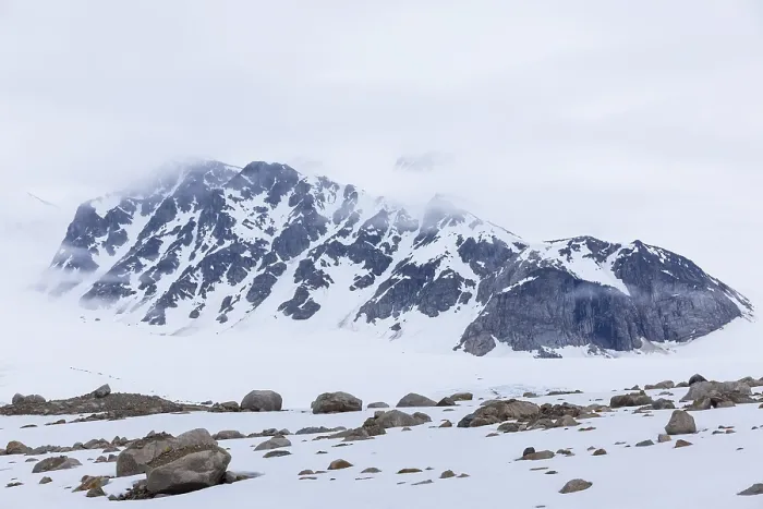 Framed Print : Large boulders in the snow, mountain range