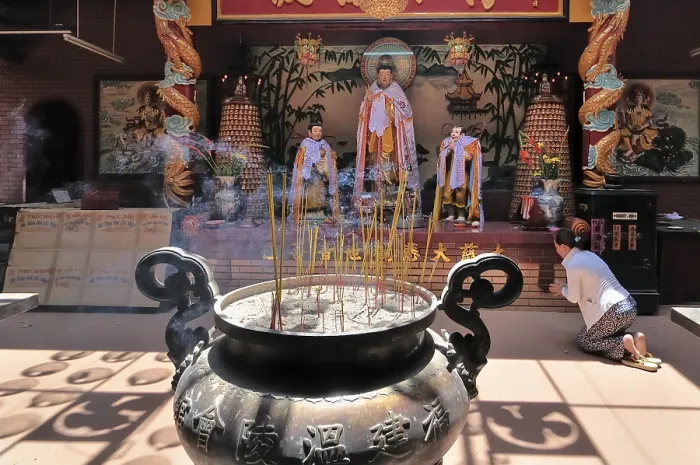 Framed Print : Large copper kettle with smoked foods in front of a Buddha altar