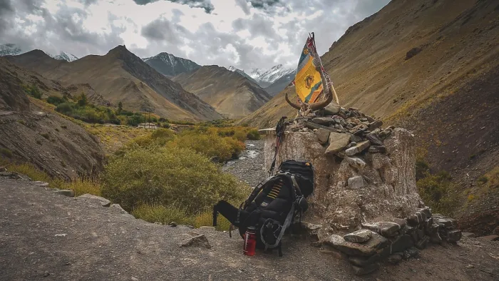 Framed Print : Large hiking backpack leaning at a stone place of worship