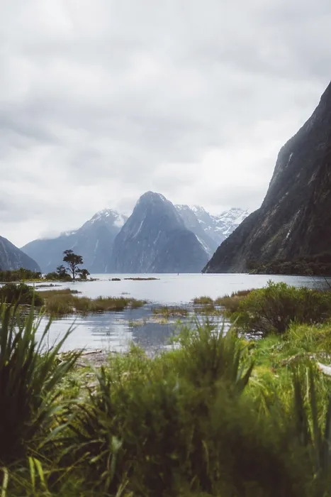 Framed Print : Large lake surrounded by high mountains and green vegetation