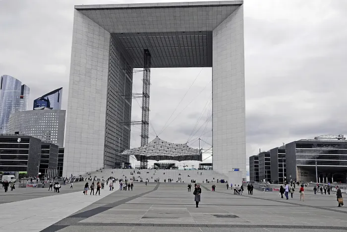 Framed Print : Large modern monument with people on the forecourt under a cloudy atmosphere