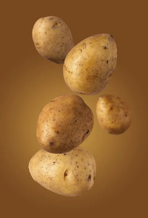Framed Print : Large ripe potatoes flies on a beige background Framed Print : Large ripe potatoes flies on a beige background