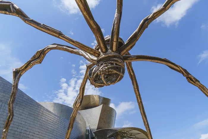 Framed Print : Large spider sculpture next to an architectural building under a blue sky