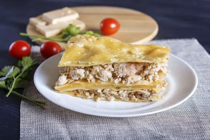Framed Print : Lasagna with minced meat and cheese on black wooden background