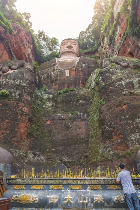 Framed Print : Leshan, China - July 2019 : Chinese male pilgrim lightening memorial candles at the bottom of The Giant Leshan Buddha Framed Print : Leshan, China - July 2019 : Chinese male pilgrim lightening memorial candles at the bottom of The Giant Leshan Buddha