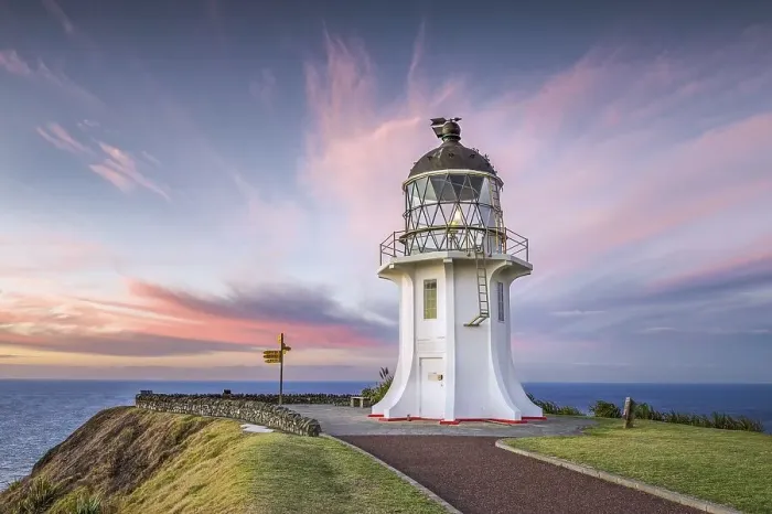 Framed Print : Lighthouse with signpost at Cape Reinga at sunset with pink clouds Framed Print : Lighthouse with signpost at Cape Reinga at sunset with pink clouds