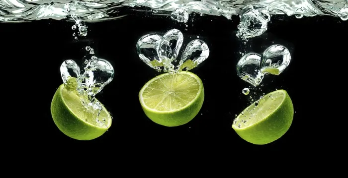 Framed Print : Three lime halves, splashing into water against black Framed Print : Three lime halves, splashing into water against black