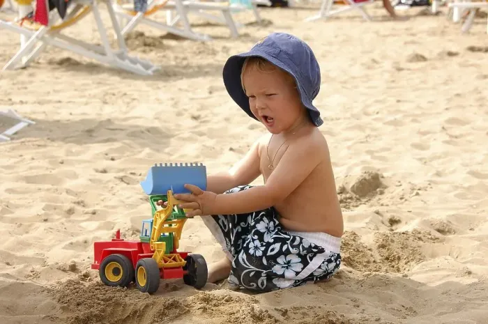 Framed Print : Little boy sitting on the beach playing