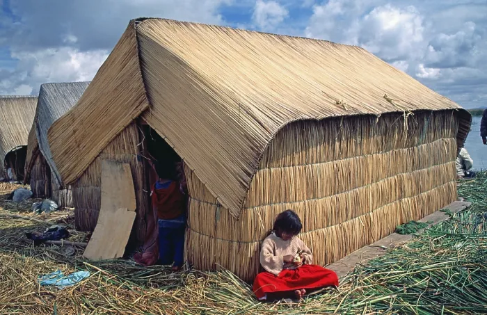 Framed Print : Little girl sitting in front of a reed hut on a floating Uro island in Lake Titcaca Framed Print : Little girl sitting in front of a reed hut on a floating Uro island in Lake Titcaca