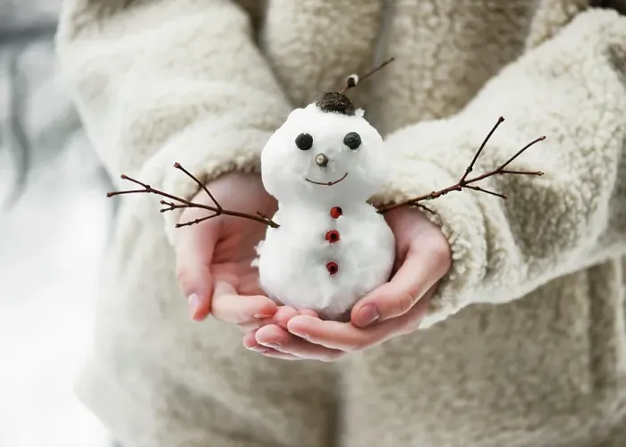 Framed Print : Little snowman, decorated with twigs and berries, held in children's hands in a winter garden with lots of snow. Winter atmosphere