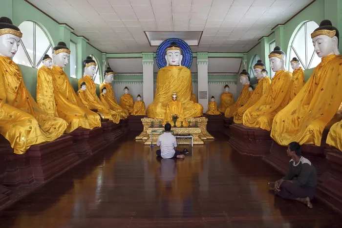 Framed Print : Local man meditating in front of Buddha statues with yellow gowns Framed Print : Local man meditating in front of Buddha statues with yellow gowns