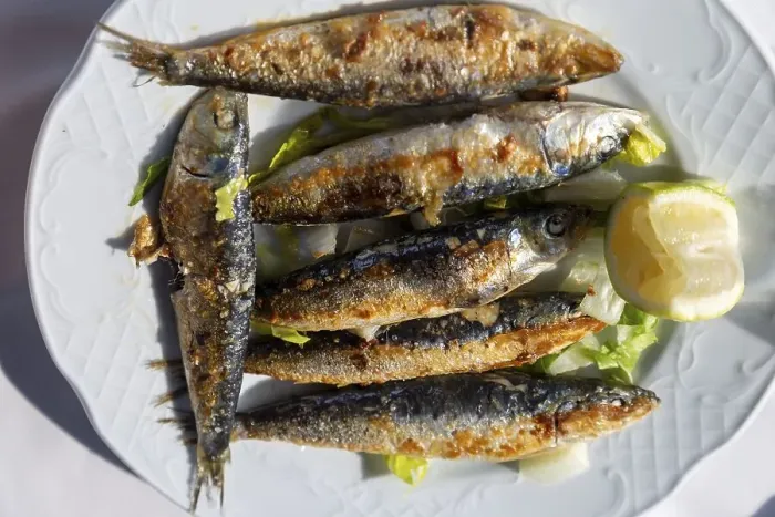 Framed Print : Looking down from overhead on white plate of freshly grilled sardines