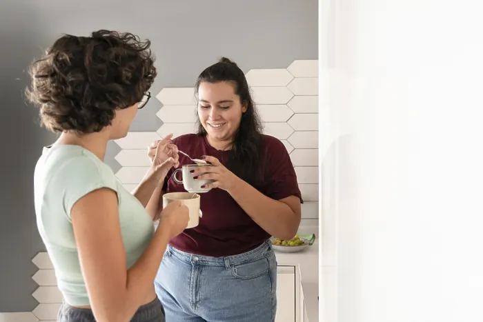 Framed Print : A loving lesbian couple enjoys a morning coffee together in their modern kitchen