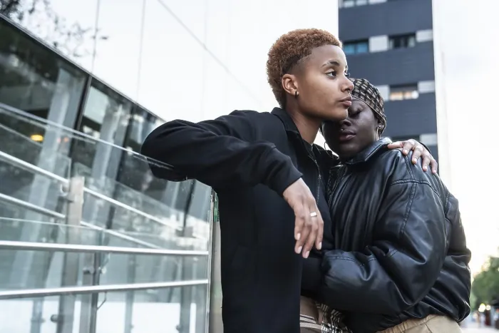 Framed Print : A loving LGBT multiethnic couple embraces outdoors in an urban environment