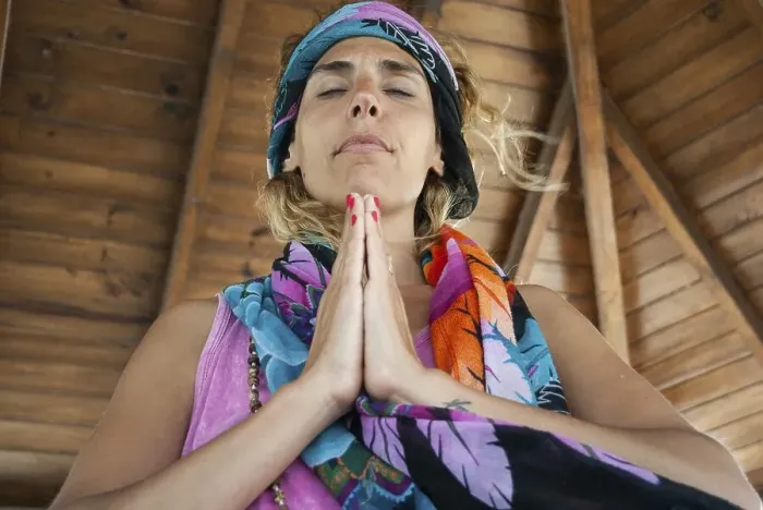 Framed Print : Low angle view of a woman clasping hands and wearing a bandana while meditating Framed Print : Low angle view of a woman clasping hands and wearing a bandana while meditating