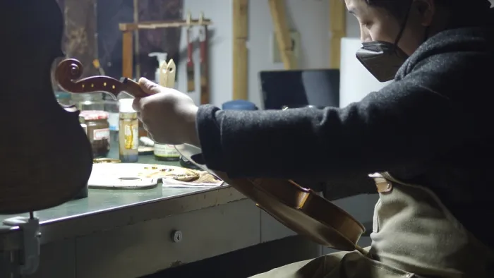 Framed Print : A luthier meticulously working on a violin in a well-equipped workshop Framed Print : A luthier meticulously working on a violin in a well-equipped workshop