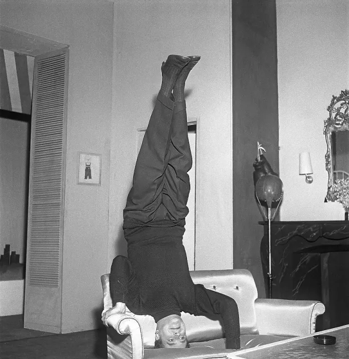 Framed Print : Man of the 1950s. A man standing on his head in a sofa