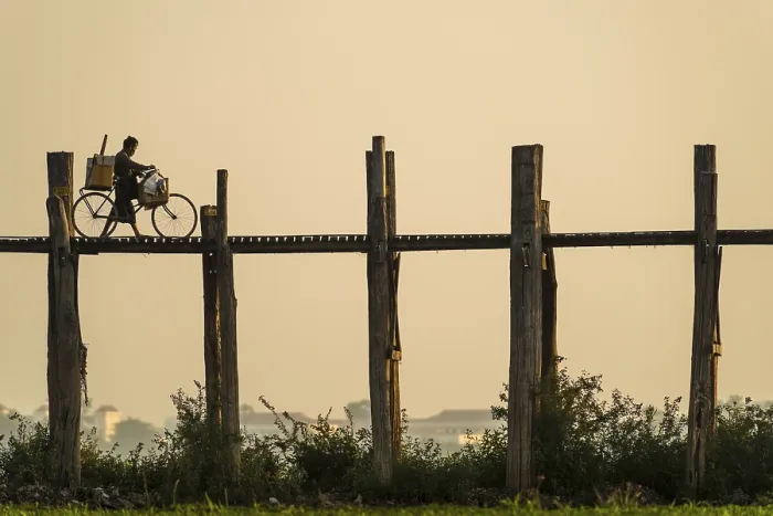 Framed Print : Man with a bike walking on a teak bridge