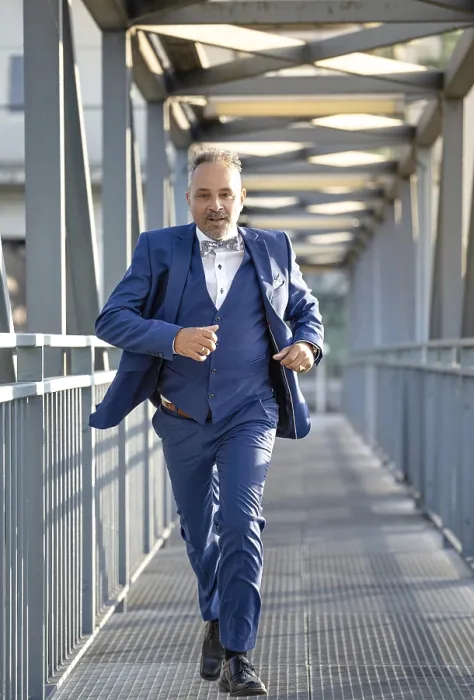 Framed Print : Man in blue suit fleeing over bridge