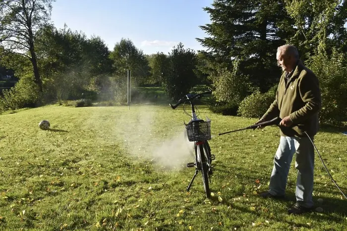 Framed Print : Man cleans bicycle with high-pressure cleaner