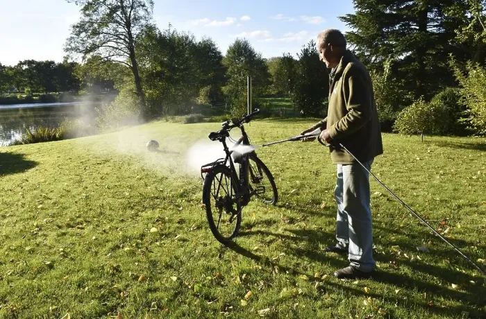 Framed Print : Man cleans bicycle with high-pressure cleaner Framed Print : Man cleans bicycle with high-pressure cleaner