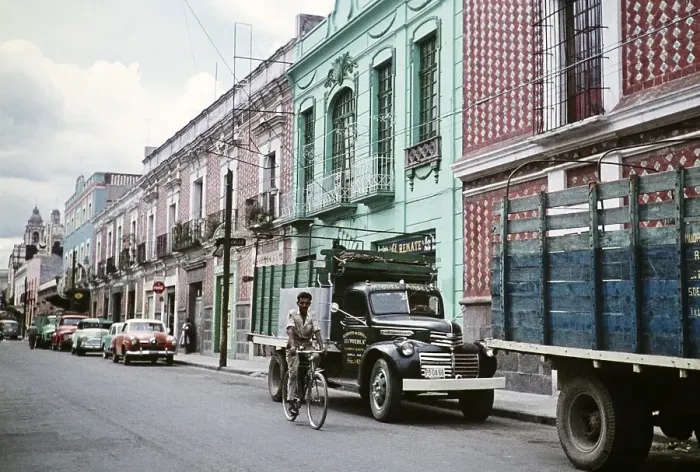 Framed Print : Man cycling past parked cars and houses, street in Puebla, Mexico, around 1961, Central America