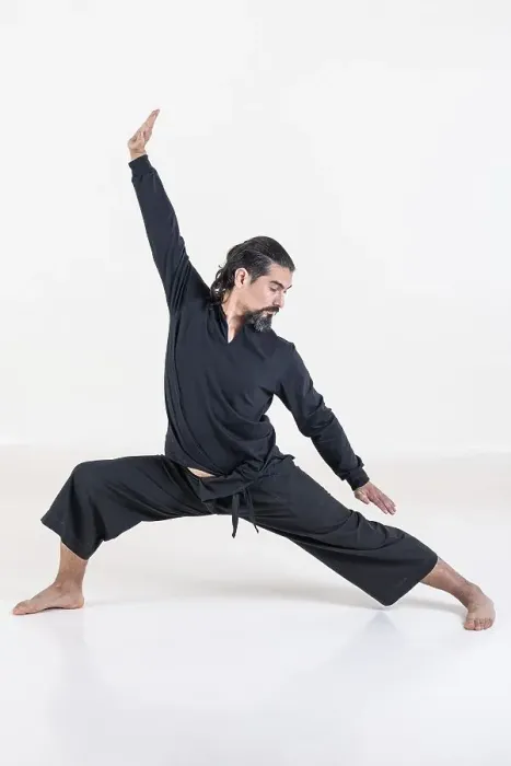 Framed Print : A man dressed in black doing yoga over white background