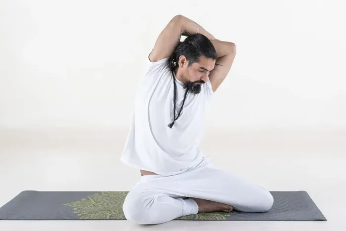 Framed Print : A man dressed in white doing yoga on a mat over white background