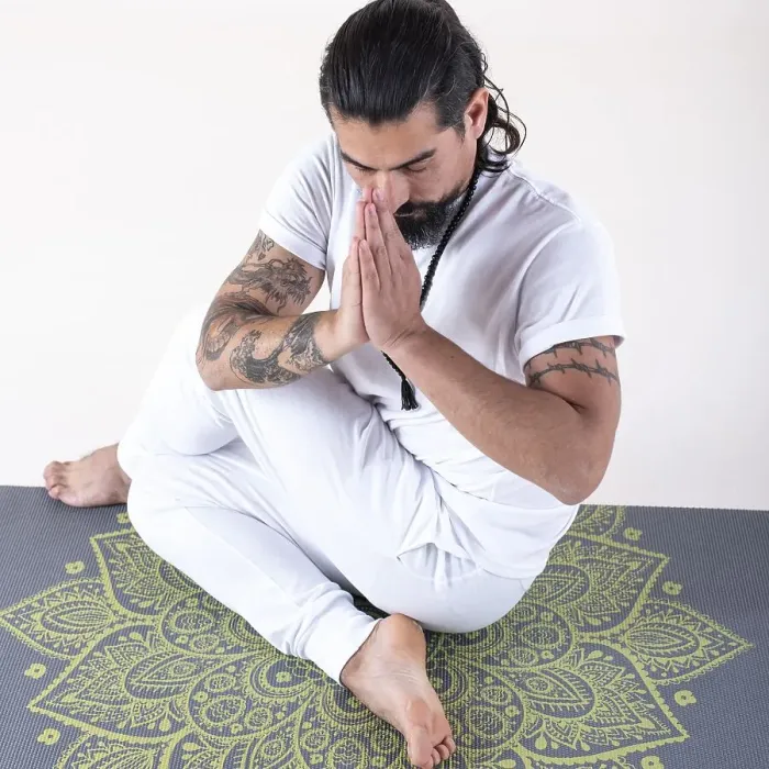 Framed Print : A man dressed in white doing yoga on a mat over white background