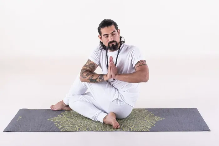 Framed Print : A man dressed in white doing yoga on a mat over white background