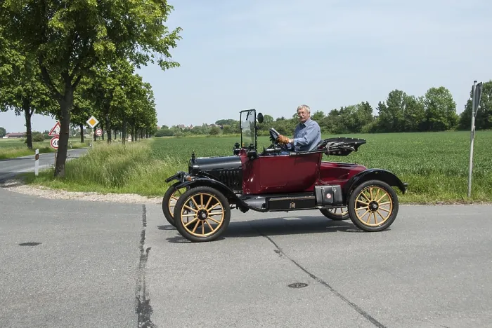 Framed Print : Man driving a classic Ford vintage car on an open country road