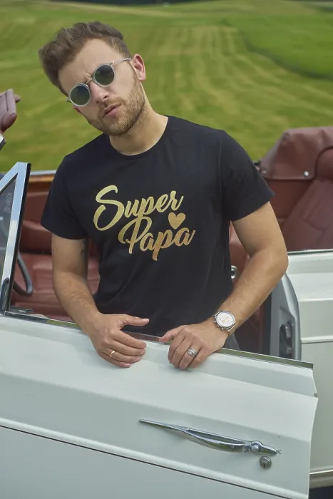 Framed Print : Man leaning on a white convertible wearing a black shirt and sunglasses in a field